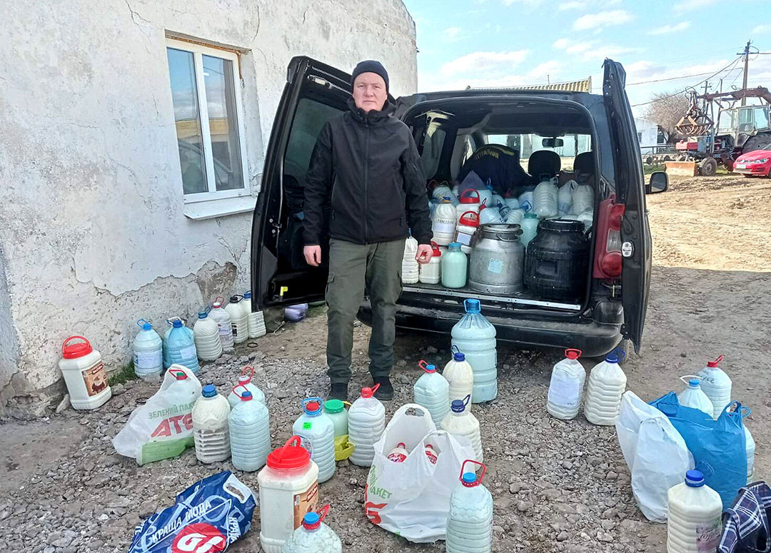 Using every container available this man collects milk to take to the local churches to distribute. Photo: Chris McCullough