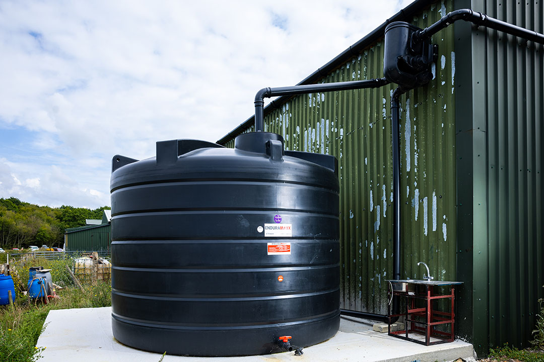 30/08/2022 - Ciaran McCrickard South East Water SEW's Tom Abbotts talks with farmer Michael Richards at Broyle Park Farm, East Sussex, and surveys the rainwater harvesting systems installed, which include a large capture tank, guttering and drainage ditches.